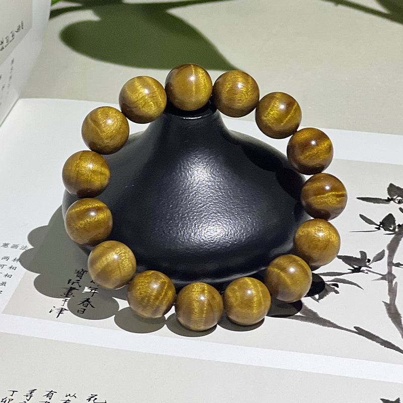 1.5 cm genuine golden nanmu wood bracelet with water ripple pattern.
